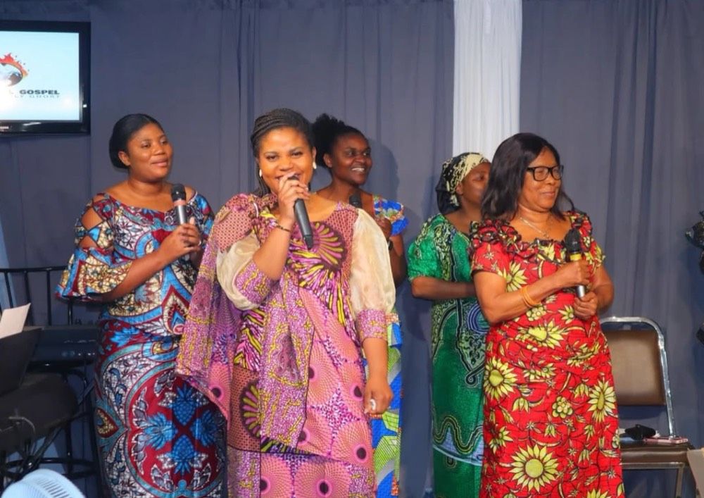Women singing in African print dresses